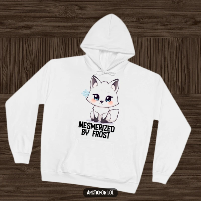 Funny hoodie depicting an arctic fox with wide, luminous eyes, mesmerized by the intricate beauty of a single falling snowflake.